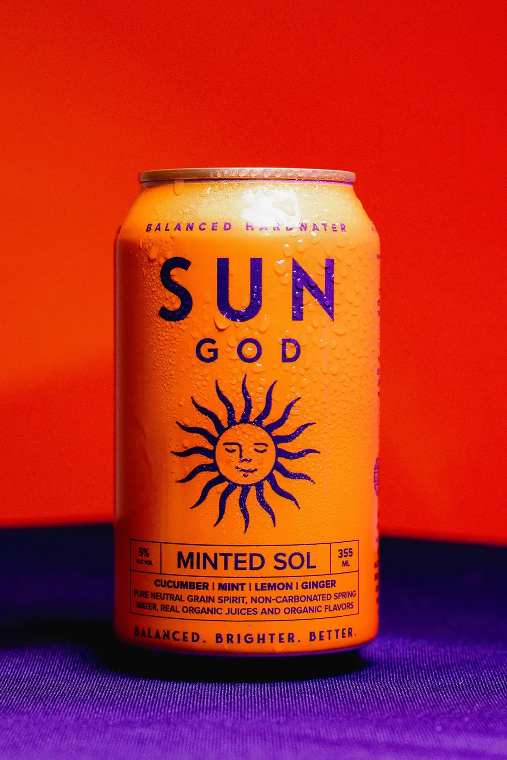 A Minted Sol can lit against a saturated orange backdrop